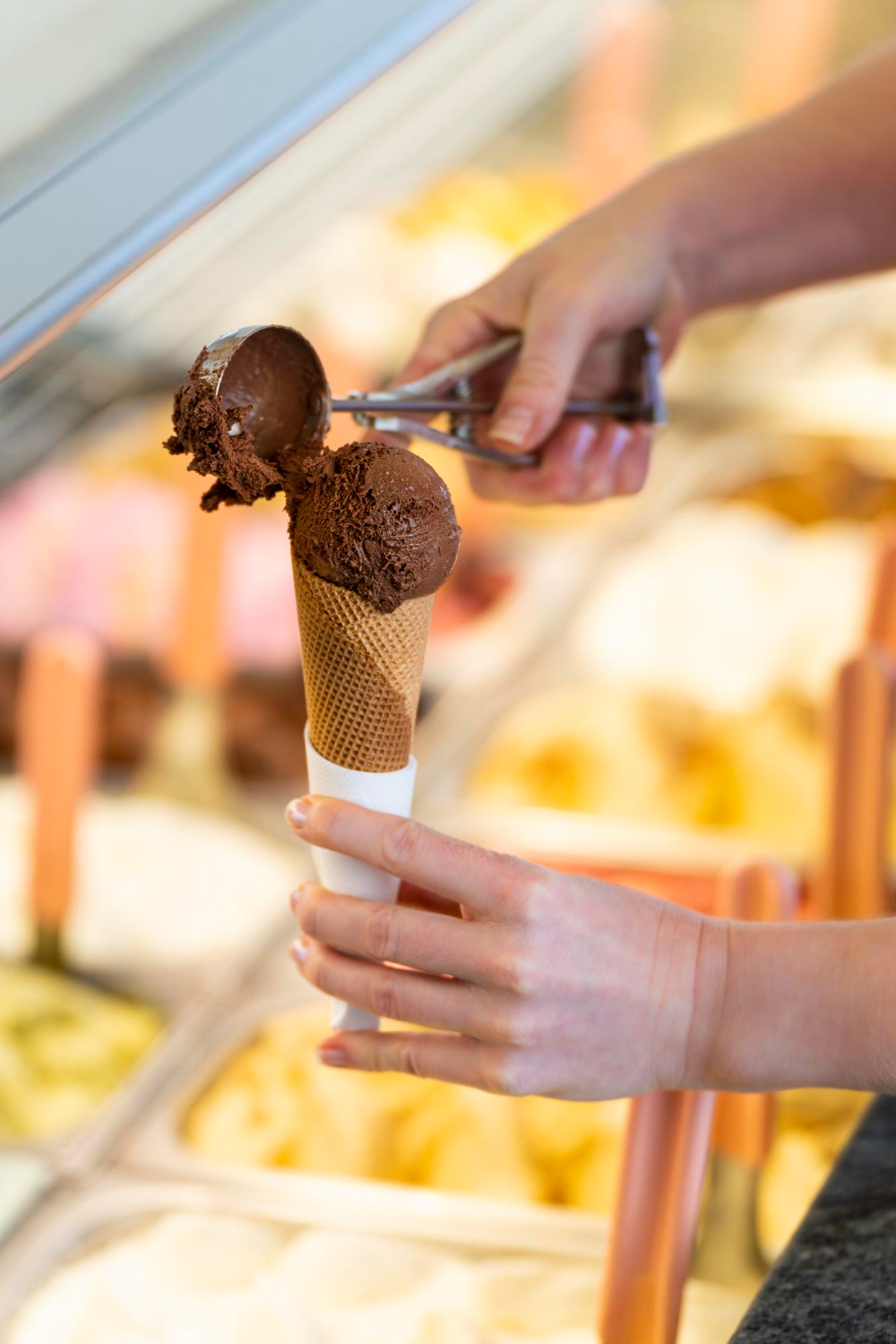 primo-piano-di-una-donna-che-prepara-un-cono-gelato-al-cioccolato